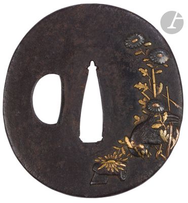 une tsuba noire ornée d'un décor doré