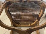 an old wooden chair sitting on a tile floor next to a wall