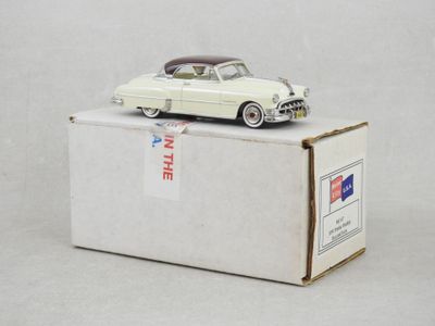 une petite voiture blanche posée sur une boîte