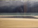 une photo d'une photo représentant une plage avec un bateau dans l'eau