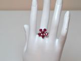 une main blanche ornée d'une bague rouge