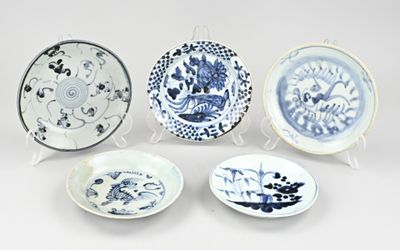 four blue and white plates with designs on them on a white surface