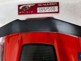 a close up of a red motorcycle with a number plate on it