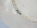 a white plate with a black spot on it