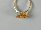 a close up of a gold ring with an orange stone