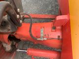 a close up of a red machine on the ground