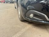 a black car parked in a parking lot with other cars in the background