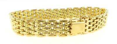 gros plan d'un bracelet en or sur fond blanc