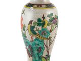 un vase blanc orné d'un motif vert et rouge