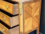 a small chest of drawers with a marble top
