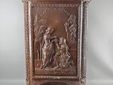 une vieille armoire en bois ornée d'une sculpture représentant un homme et une femme