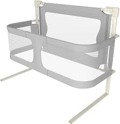 grey and white baby crib with a baby bed attached to it ' s side