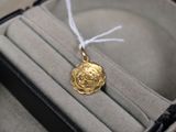 une pièce d'or dans un écrin à bague, entourée d'un fil blanc