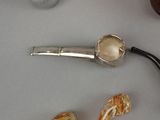 a silver pipe and a glass pipe holder on a table