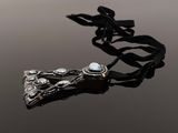 a close up of a necklace on a table with a black ribbon