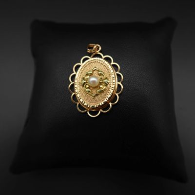 un pendentif plaqué or avec une perle au centre