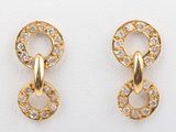 two pairs of gold earrings with diamonds on them on a white surface