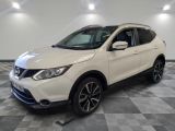 un SUV Nissan blanc garé sur un sol à damier dans un garage
