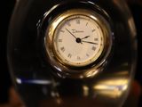 a glass clock sitting on top of a table