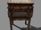 a small table with a marble top on a gray background