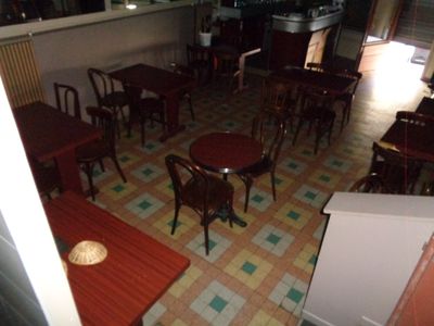 Il y a beaucoup de tables et de chaises dans ce petit restaurant.