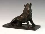 sculpture en bronze représentant un chien assis sur un socle, sur fond blanc