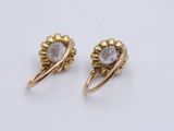 a pair of gold and diamond earrings on a white background