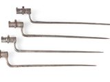un ensemble de quatre vieux outils en métal posés sur une surface blanche