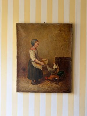un tableau représentant une femme en train de nourrir un poulet, accroché au mur