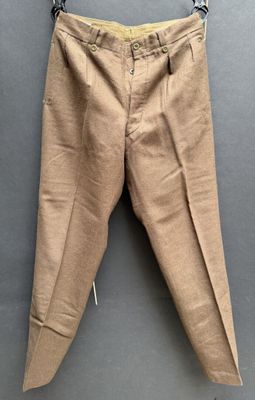 un vieux pantalon suspendu à un cintre accroché au mur