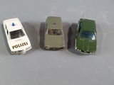 three toy cars sitting next to each other on a table
