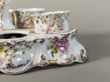 a white and purple flowered tea set on a table