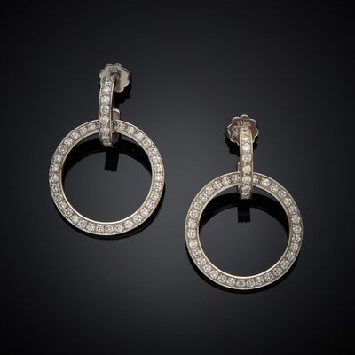 a pair of diamond earrings, by person