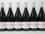 six bouteilles de vin sont alignées sur une table