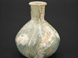 a green vase that is sitting on a black surface