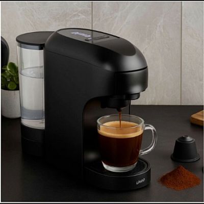a black coffee maker with a cup of coffee next to it