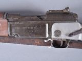 an old gun with a wooden handle on a white surface