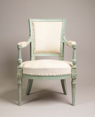 une image représentant une chaise verte dont l'assise est recouverte de tissu blanc