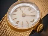 un gros plan d'une montre en or sur fond noir