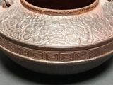 a brown vase sitting on top of a table