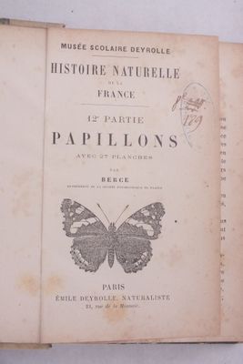 un livre orné d'un papillon, posé sur une table
