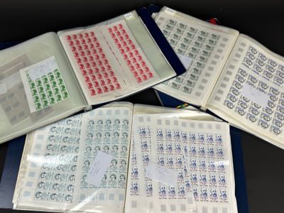 trois livres ouverts, sur lesquels sont apposés des timbres, posés sur une table