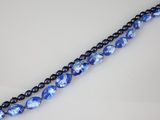 a strand of blue glass beads on a white surface