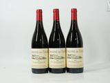three bottles of red wine sitting next to each other on a table