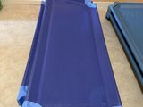 a blue cot that is on the floor next to a blue cot