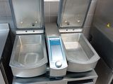 three sinks in a public bathroom with a digital scale on them