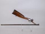 an old gun with a wooden handle on a metal stand