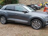 the grey volkswagen suv is parked in a lot with other cars
