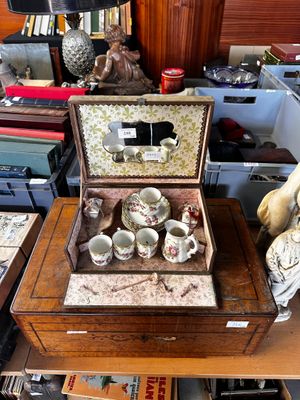 une petite boîte en bois contenant des tasses à thé, posée sur une table