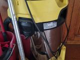 a yellow and black vacuum sitting on the floor next to a red bucket